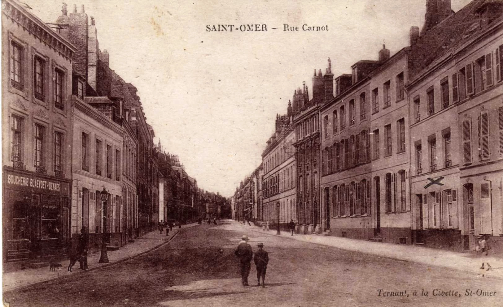 (l)- Tout en bas de la rue